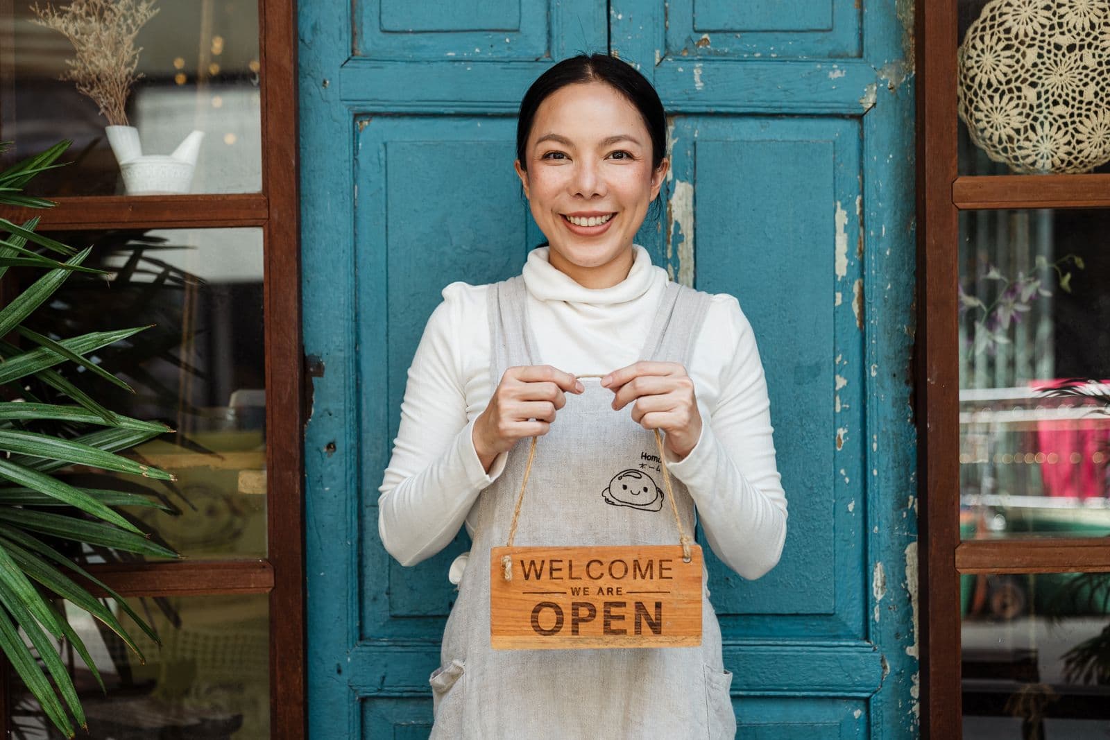 Small-business owner holding an OPEN sign